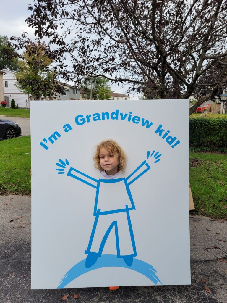 Alden with a cut-out poster around his head.