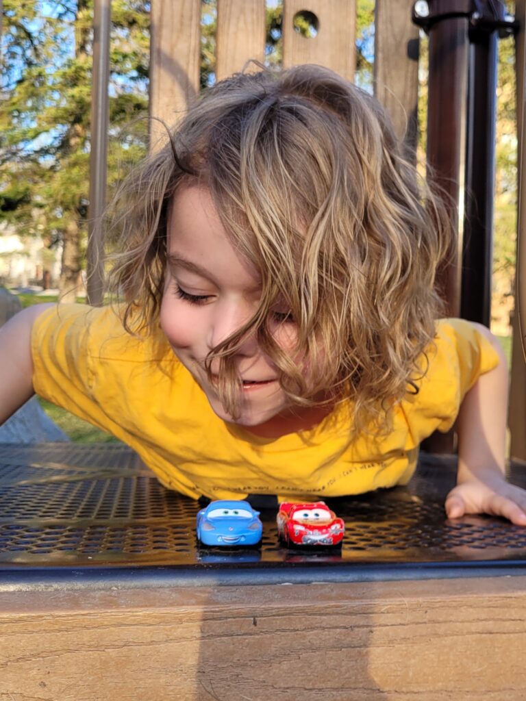 Alden playing with small car toys.