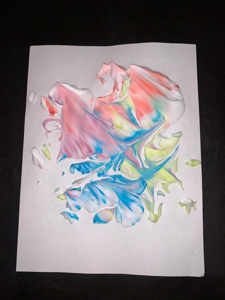 Colourful shaving cream on a sheet of paper.
