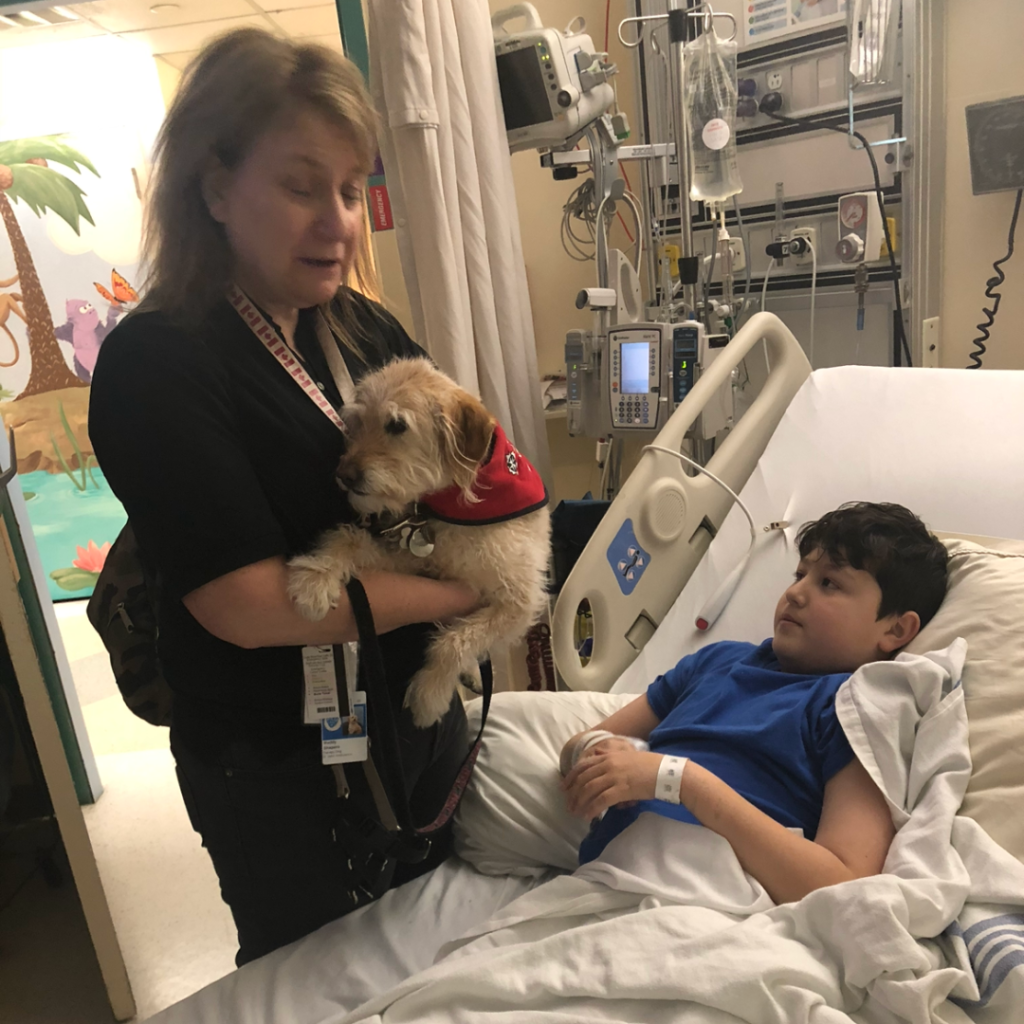 Claudia's son, Reid, sitting in the hospital bed for rehabilitation.