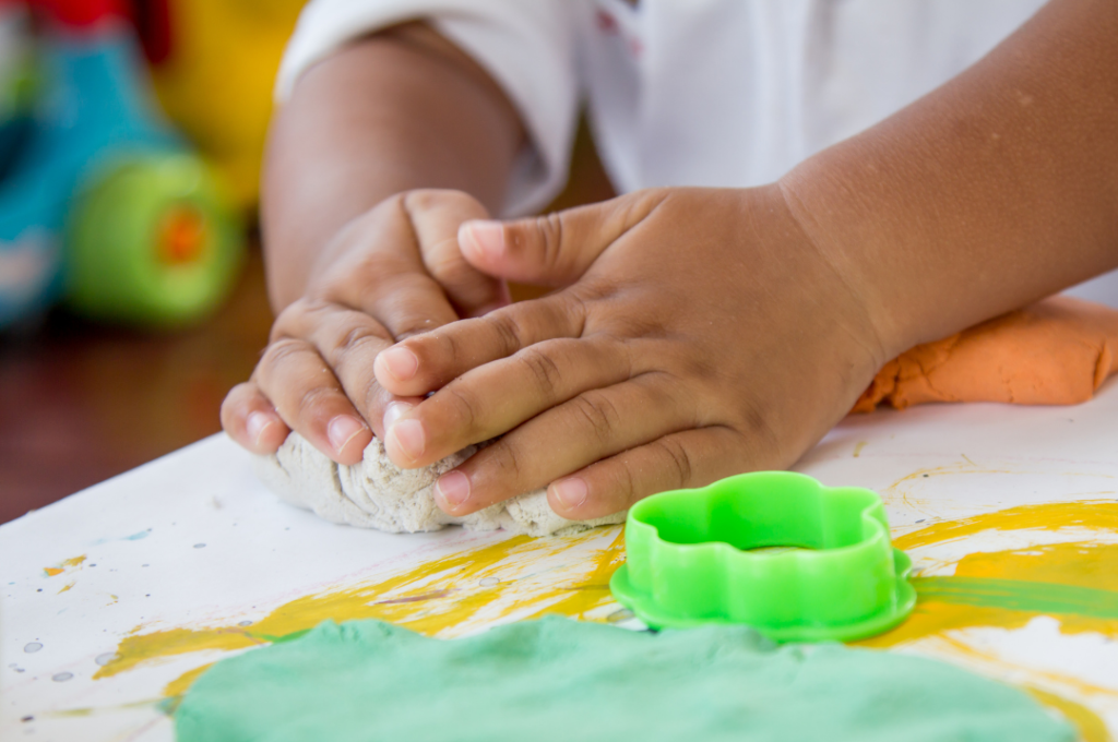 Image of a little child kneading play-dough.