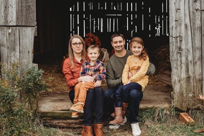 A smiling Charlie with his parents and sister.