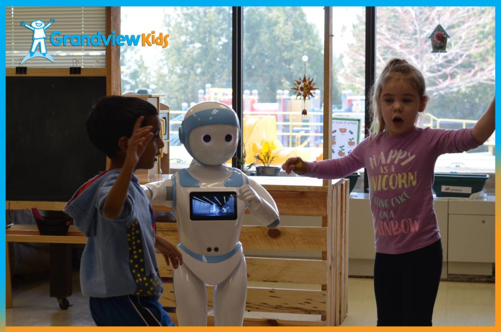 Two children playing with Joy the Robot.