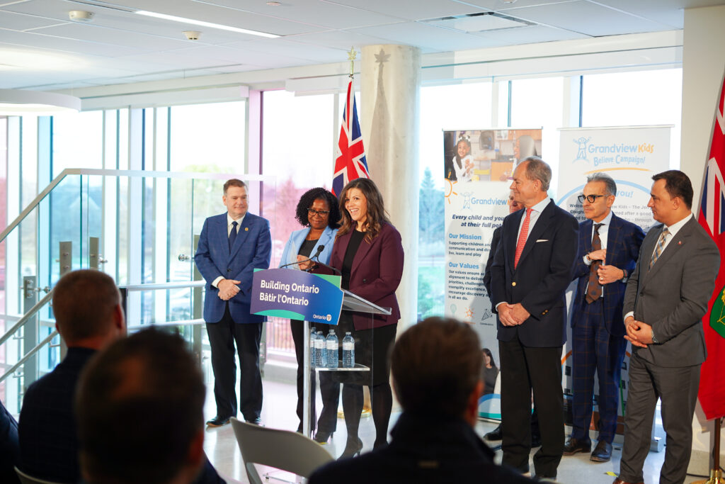 Leisa speaking at the Ribbon Cutting Ceremony in front of a podium that reads "Building Ontario."