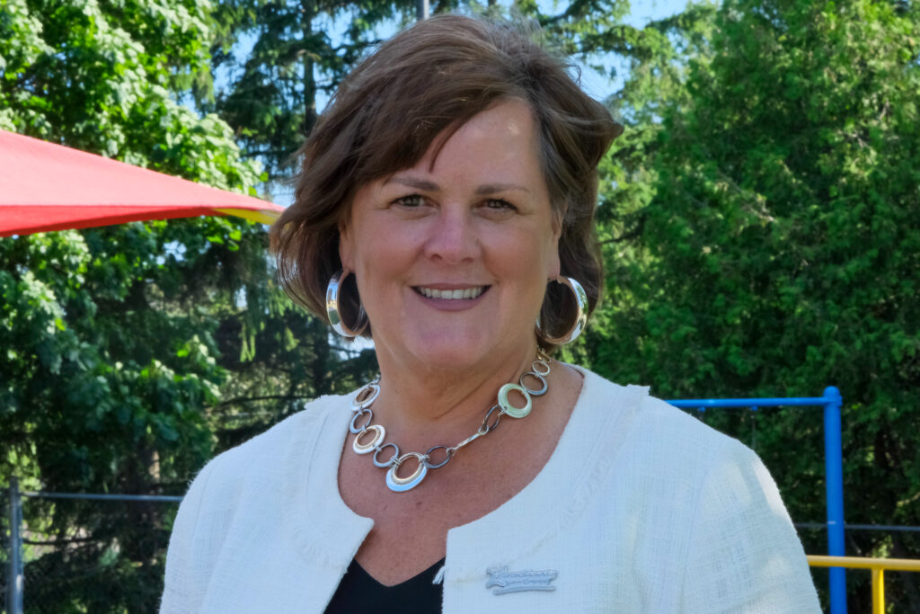 A headshot of Lorraine Sunstrum-Mann in front of the playground at Grandview Kids' Main Site in Oshawa.