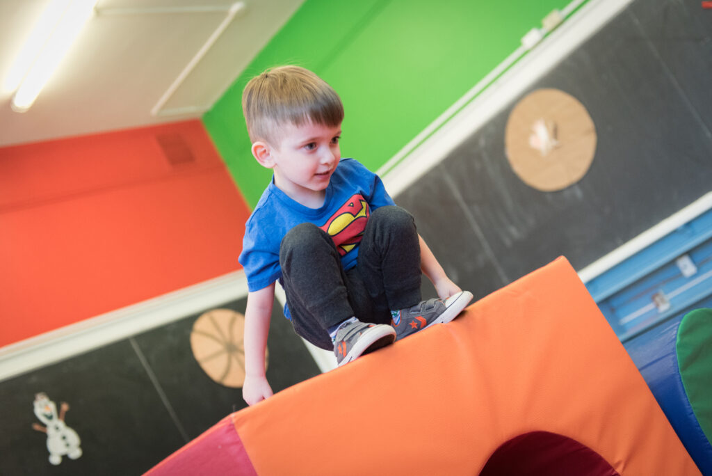 Little boy squatting on top of a tall block in Dr. Meghann Lloyd's lab.