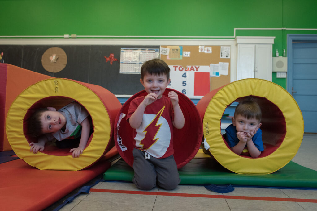 Three little boys posing in and outside of play tubes in Dr. Meghann LLoyd's lab.