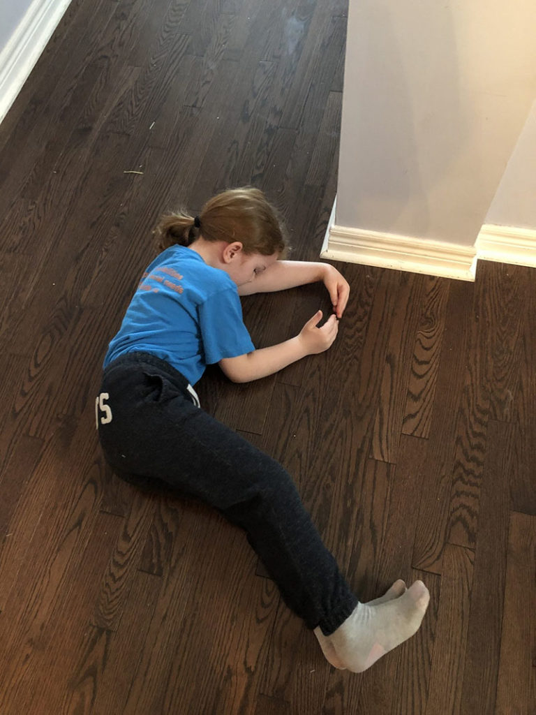 Girl stretching on floor to mimic letters