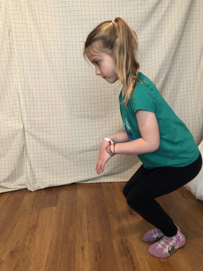 Girl acting out a kangaroo's jump.