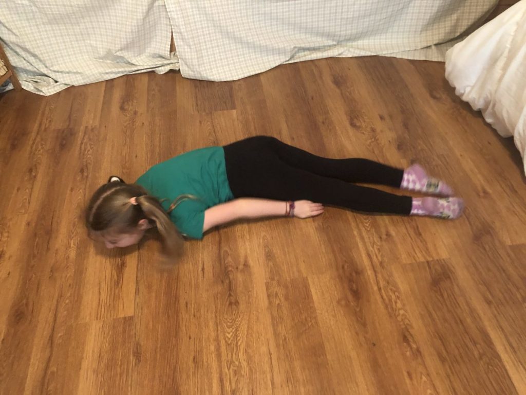 A girl doing the snake slither exercise 