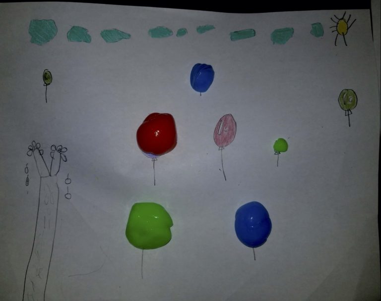 Colourful balloons on a sheet of paper made out of putty.