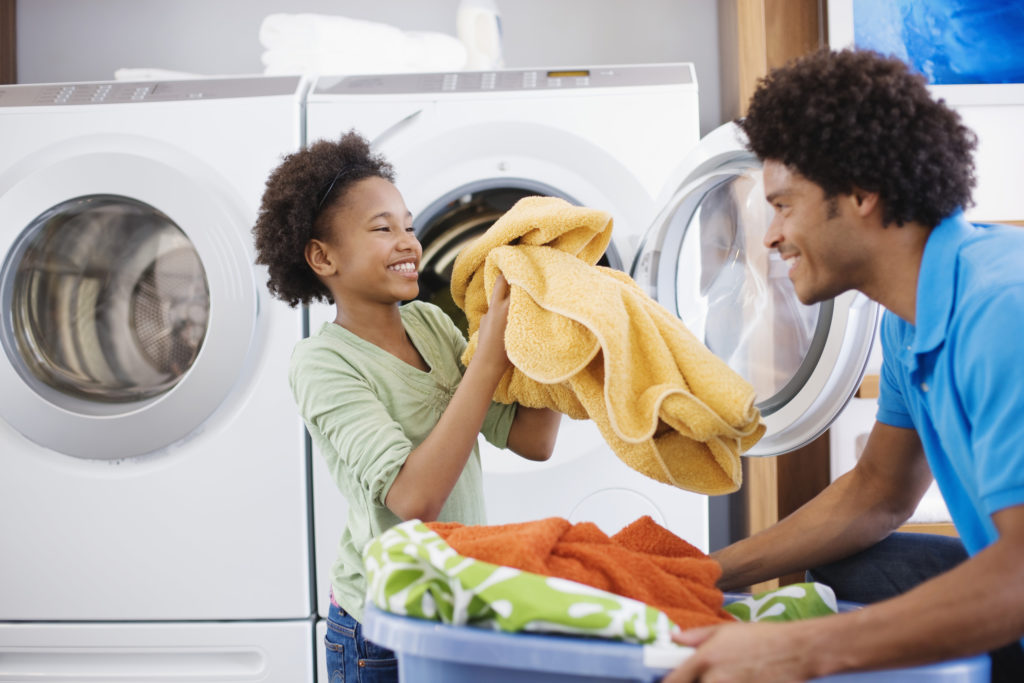 A father and child doing laundry.