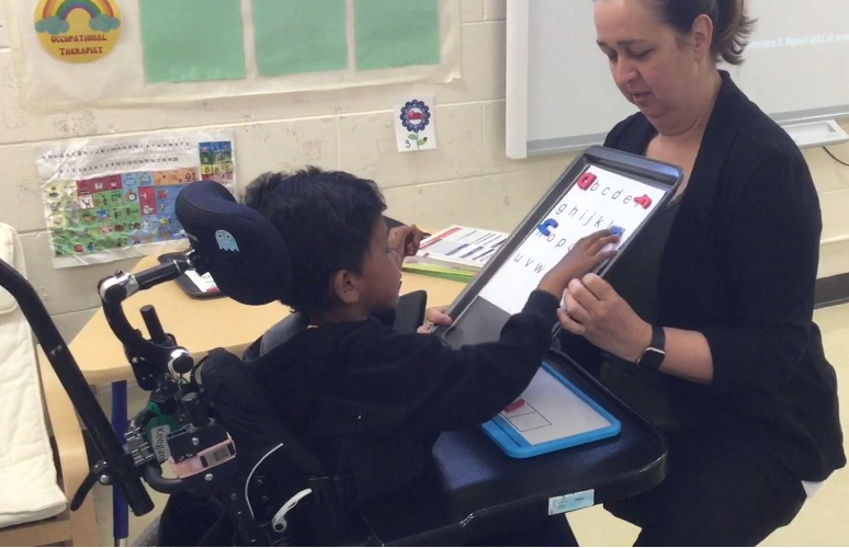 A student selects letter sound magnets to build a word.