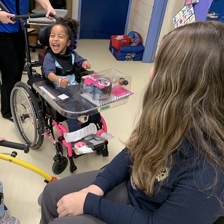 Little girl in wheelchair excited about her new barbie toy