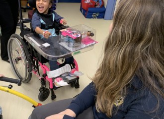 Little girl in wheelchair excited about her new barbie toy